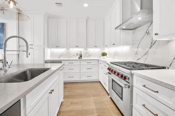 a kitchen with granite countertop a sink a stove and cabinets