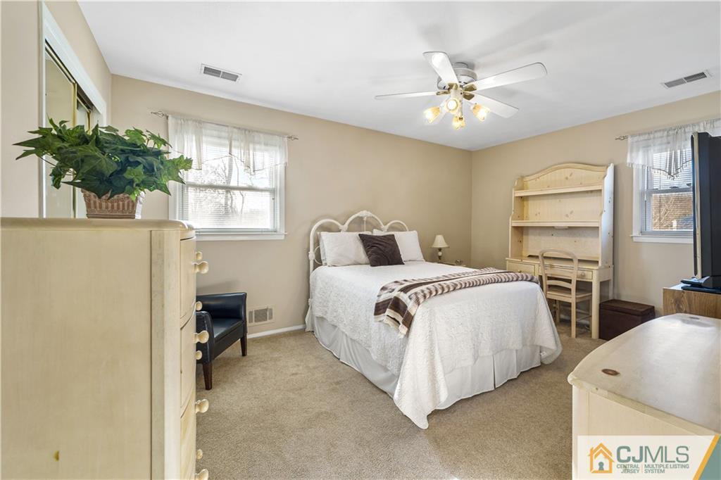 6 Albemarle Road East Brunswick, NJ 08816 - Photo 15 of 30 a bedroom with a large bed and a chandelier