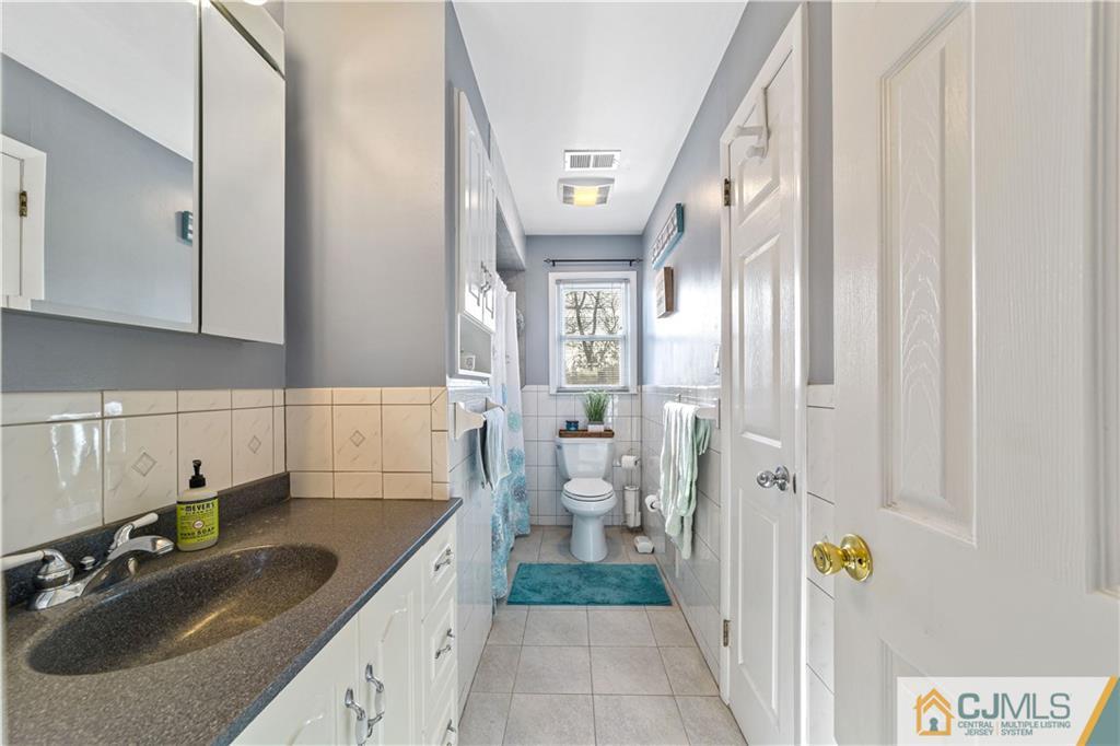 6 Albemarle Road East Brunswick, NJ 08816 - Photo 19 of 30 a bathroom with a sink and mirror with bathtub