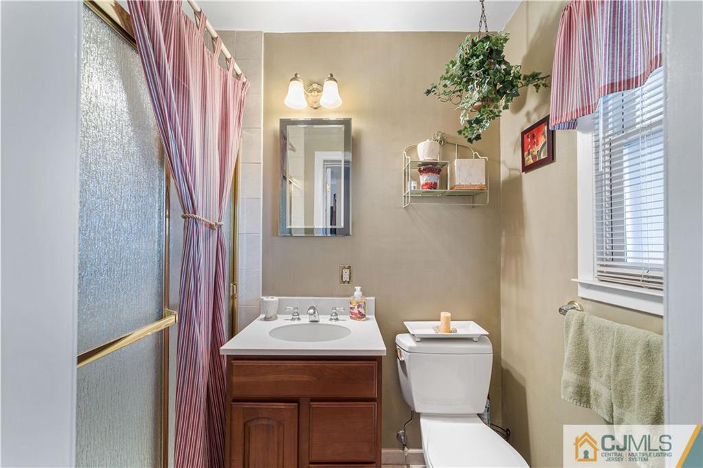 6 Albemarle Road East Brunswick, NJ 08816 - Photo 6 of 30 a bathroom with a sink a toilet and shower curtain