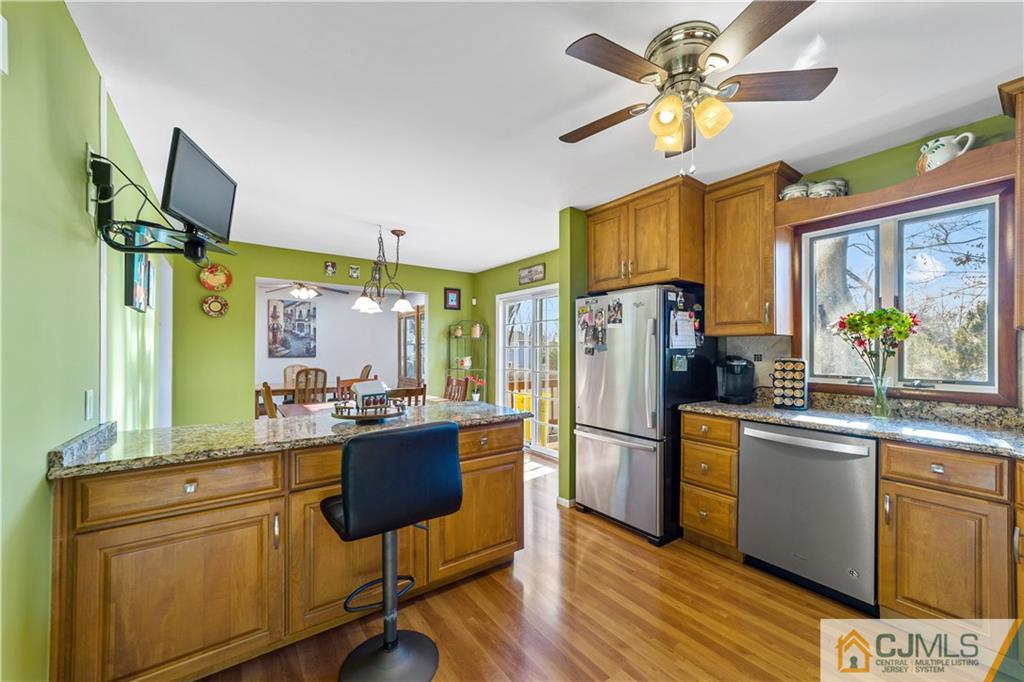 6 Albemarle Road East Brunswick, NJ 08816 - Photo 9 of 30 a kitchen with stainless steel appliances granite countertop a refrigerator a sink dishwasher a stove and a dining table with wooden floor