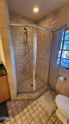 a bathroom with a granite countertop sink toilet and shower
