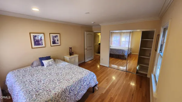 a bedroom with a bed and a refrigerator