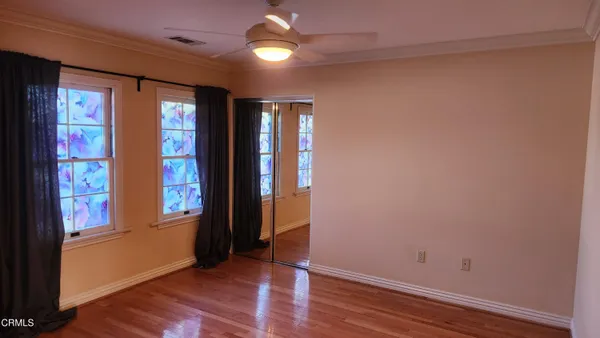 a view of empty room with wooden floor