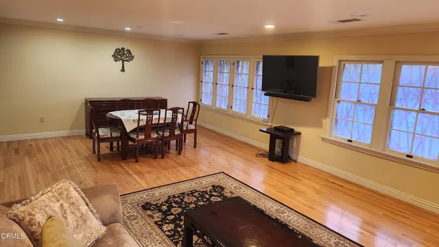 a view of a livingroom with furniture a flat screen tv and wooden floor