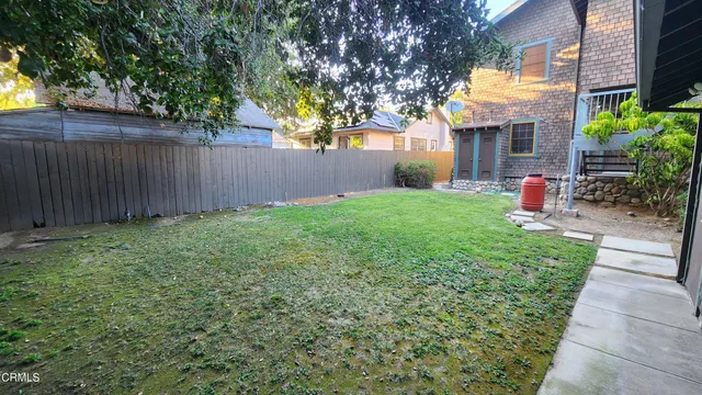 a view of a backyard with a fountain plants and large tree