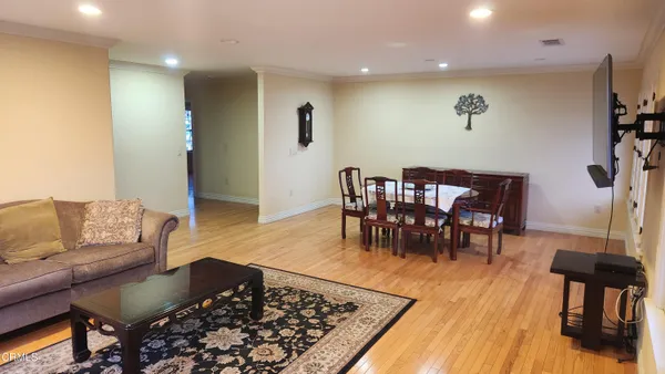 a living room with furniture and a wooden floor