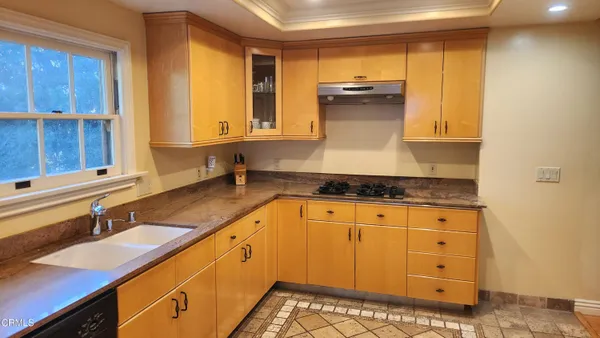 a kitchen with granite countertop a sink a stove and cabinets