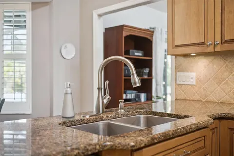 a kitchen with stainless steel appliances granite countertop a sink a stove a refrigerator a washer and dryer