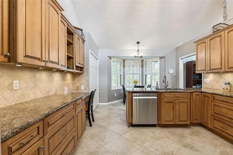 a kitchen with granite countertop a stove top oven microwave and cabinets