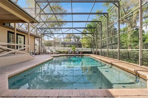 an aerial view of residential house with outdoor space and trees all around