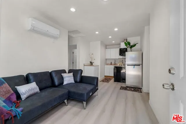 a living room with furniture and a refrigerator