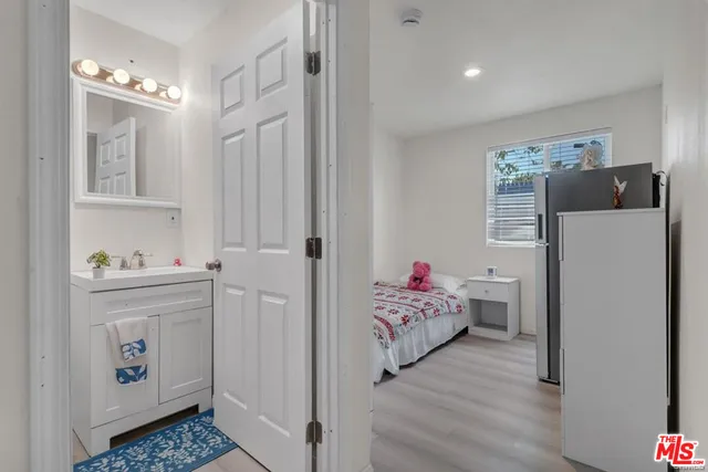 a bedroom with a bed and a refrigerator