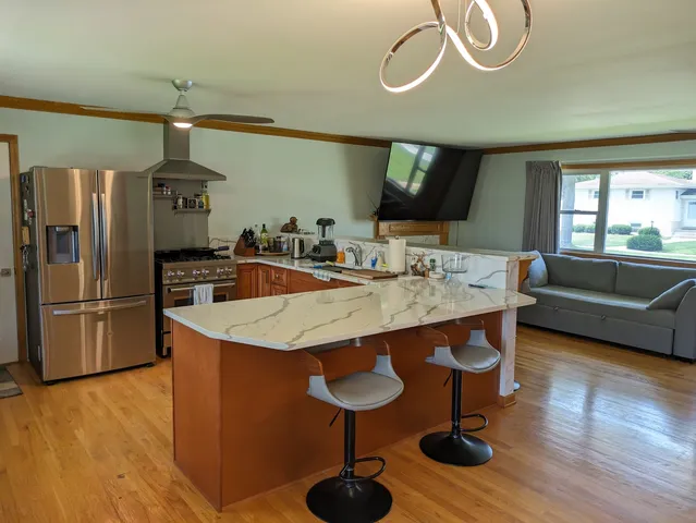 a kitchen with stainless steel appliances granite countertop a sink a stove and refrigerator