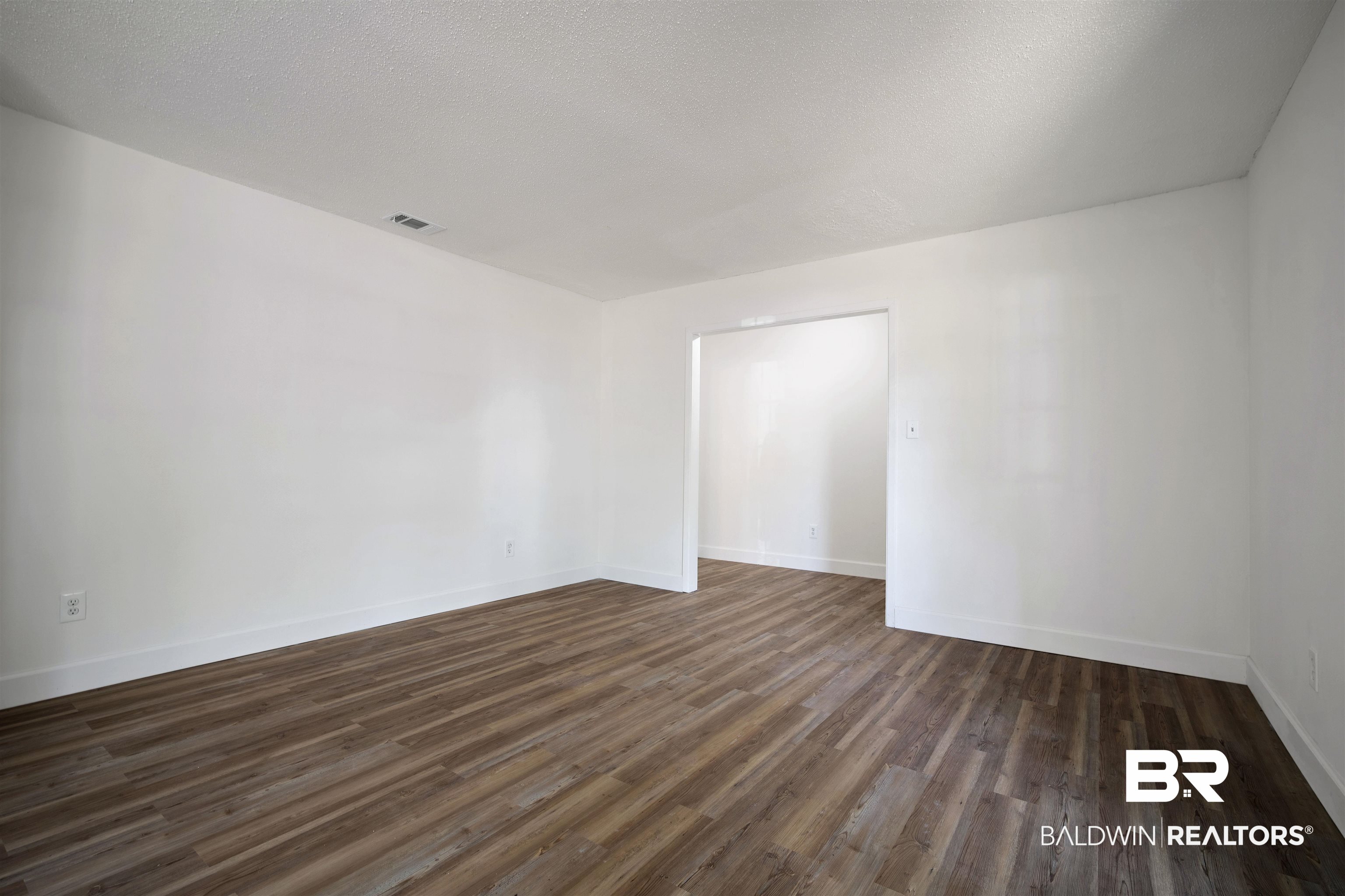 6521 Valor Court Mobile, AL 36618 - Photo 15 of 29 Unfurnished room with dark hardwood / wood-style floors and a textured ceiling