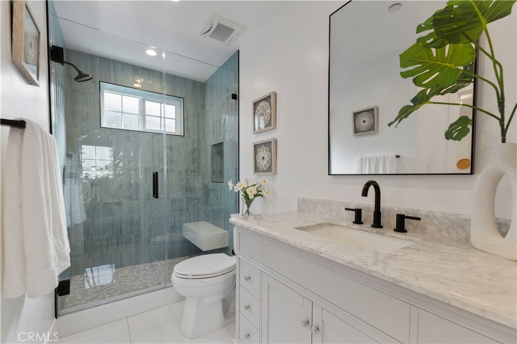 5248 Segals Way Sherman Oaks, CA 91411 - Photo 23 of 37 a bathroom with a toilet a sink and glass door