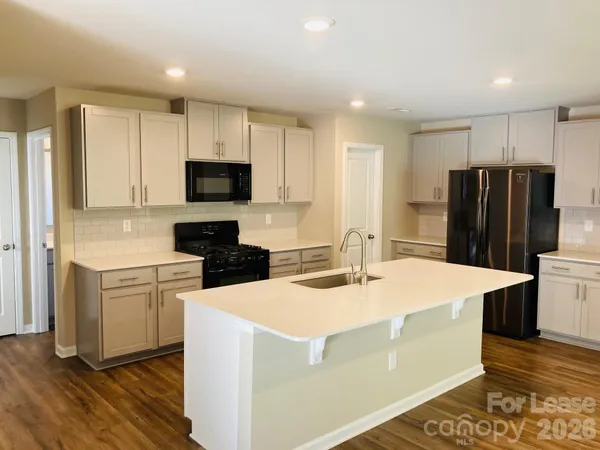 a kitchen with a appliances a sink and a refrigerator