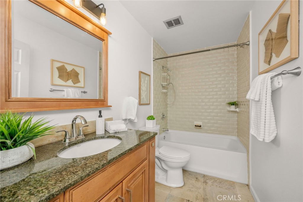 2844 East 3rd Street, Unit 210 Long Beach, CA 90814 - Photo 14 of 23 a bathroom with a granite countertop sink a toilet a mirror a shower and bathtub
