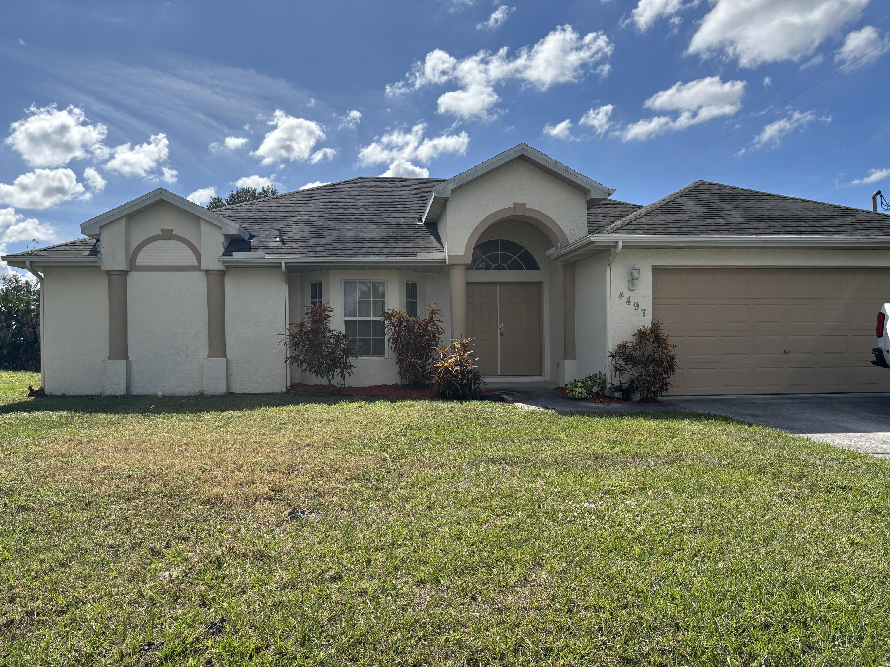 4497 Southwest Gadshaw Road Port St. Lucie, FL 34953 - Photo 1 of 13 a front view of a house with garden