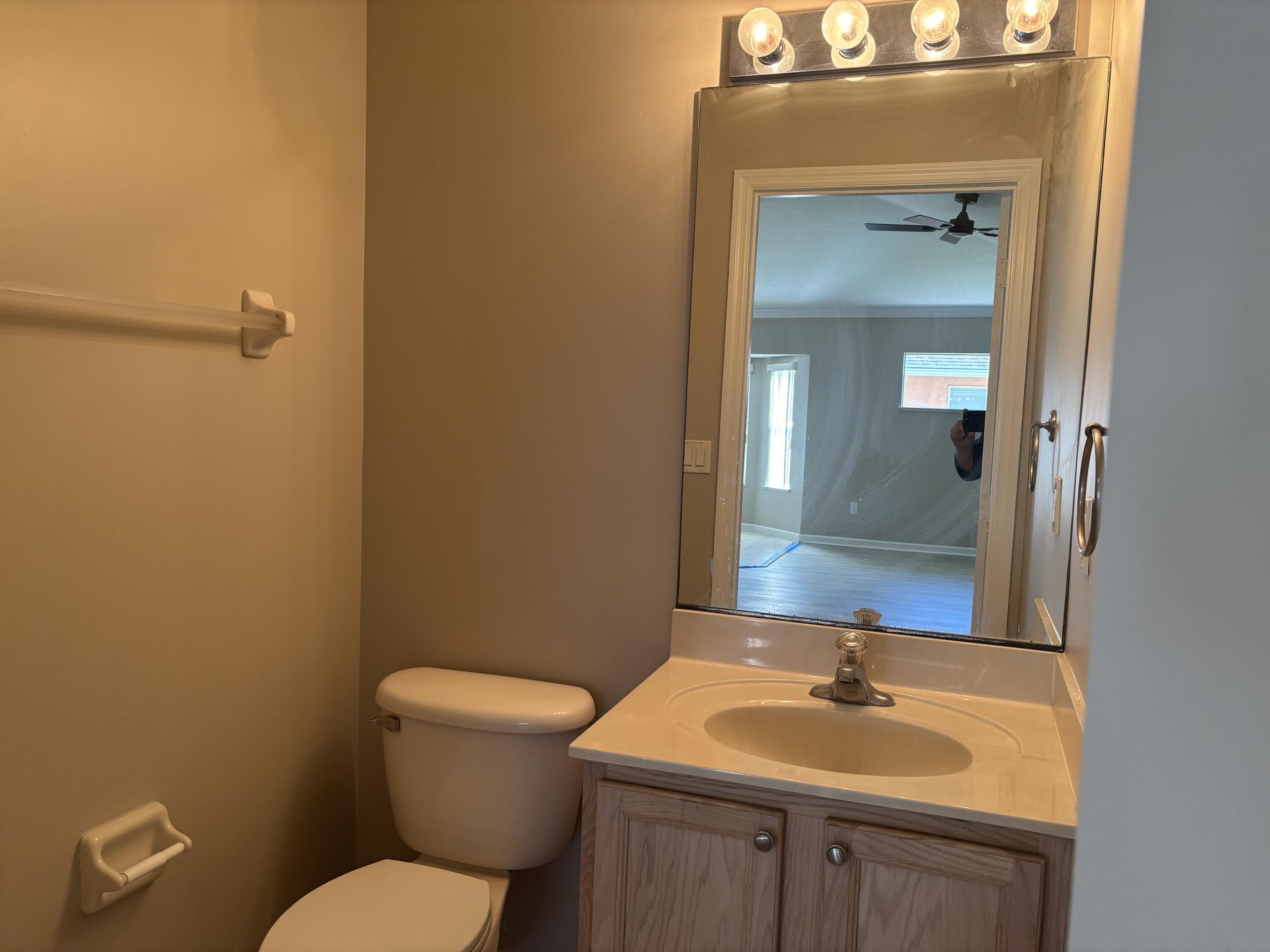 4497 Southwest Gadshaw Road Port St. Lucie, FL 34953 - Photo 11 of 13 a bathroom with a granite countertop sink toilet and mirror