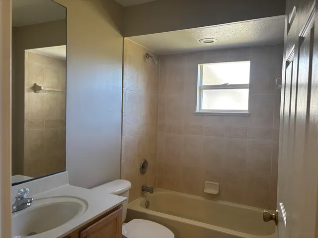 a bathroom with a granite countertop toilet a sink and bathtub