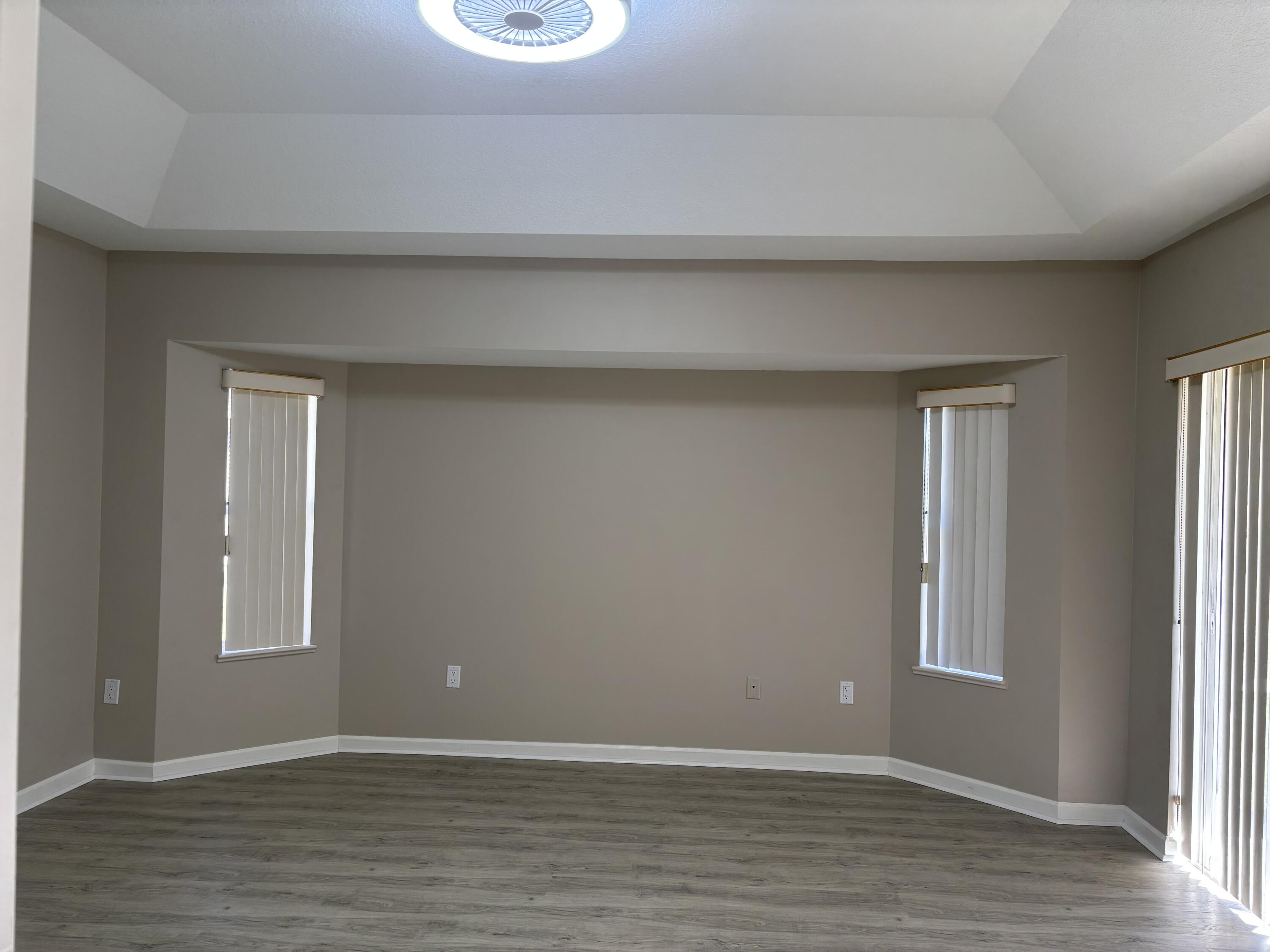 4497 Southwest Gadshaw Road Port St. Lucie, FL 34953 - Photo 4 of 13 a view of an empty room with wooden floor and a window