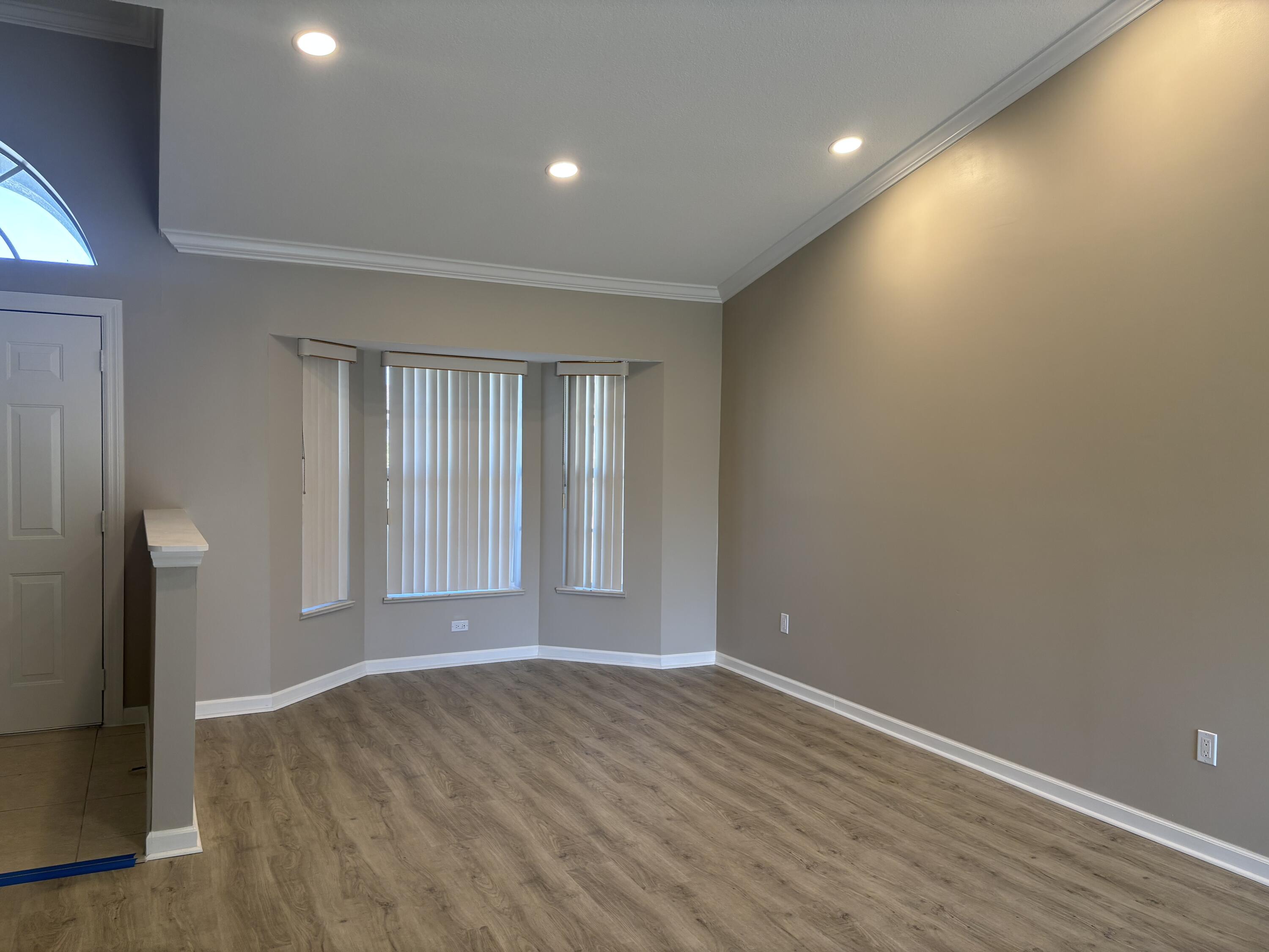 4497 Southwest Gadshaw Road Port St. Lucie, FL 34953 - Photo 6 of 13 wooden floor in an empty room with a window