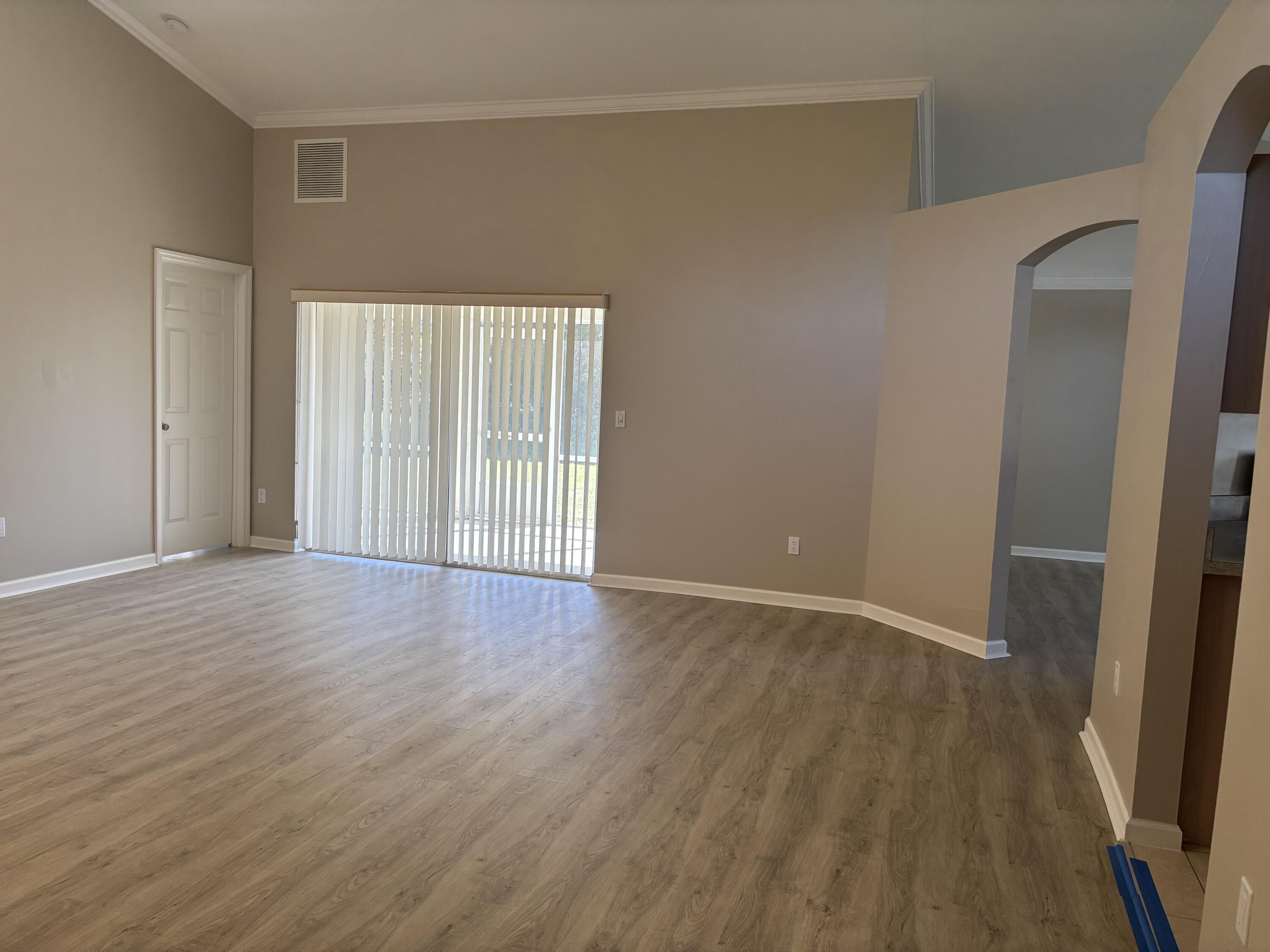 4497 Southwest Gadshaw Road Port St. Lucie, FL 34953 - Photo 7 of 13 a view of an empty room with wooden floor and a window