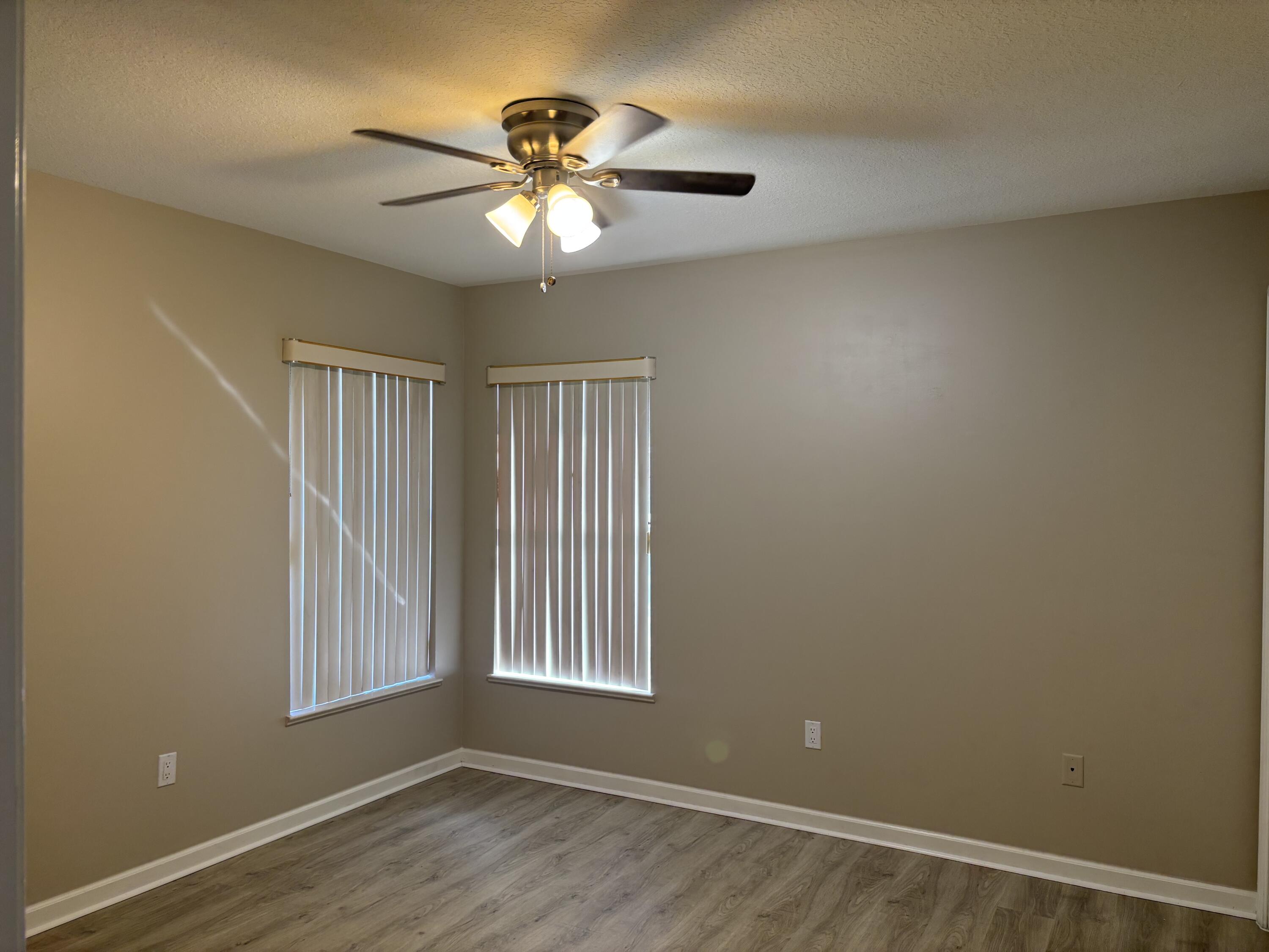 4497 Southwest Gadshaw Road Port St. Lucie, FL 34953 - Photo 9 of 13 a view of an empty room with a window and wooden floor