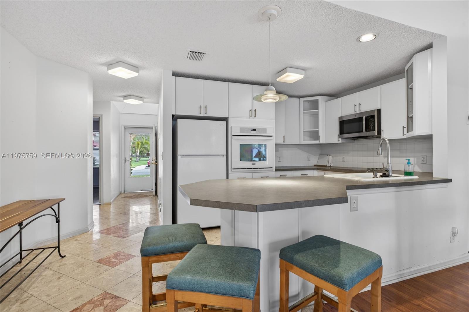 6708 North Pine Island Road Tamarac, FL 33321 - Photo 14 of 40 a kitchen with stainless steel appliances granite countertop a stove a sink a refrigerator a microwave and a refrigerator