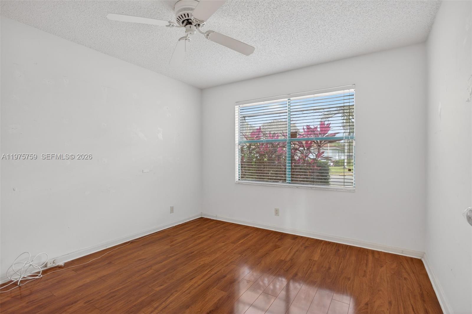 6708 North Pine Island Road Tamarac, FL 33321 - Photo 17 of 40 a view of an empty room with wooden floor and a window