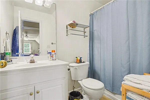a bathroom with a sink a toilet a mirror and shower curtain