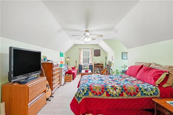 a living room with furniture a flat screen tv and a bed