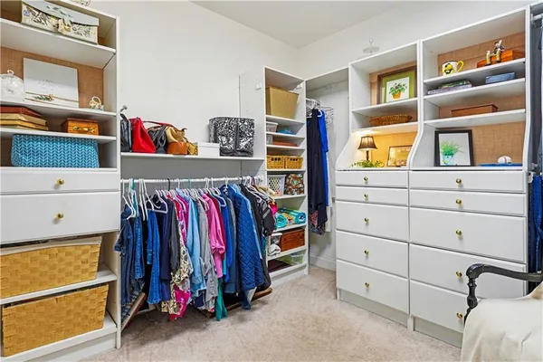 a view of walk in closet with clothes