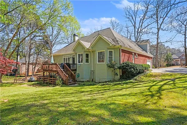 a view of a house with a small yard plants and large tree
