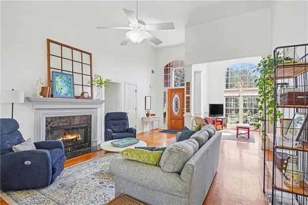 a living room with furniture fireplace and a large window