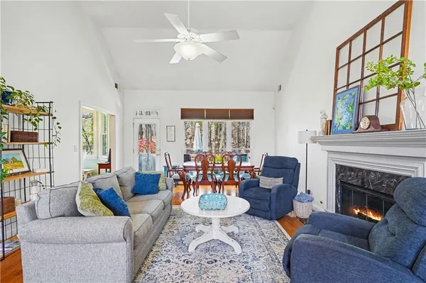 a living room with furniture a fireplace and a chandelier