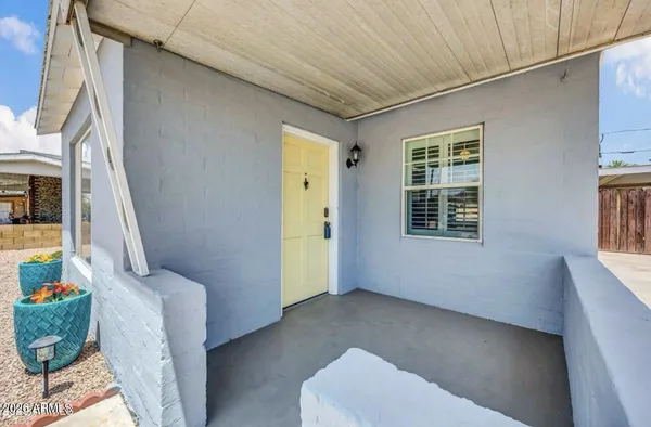 a view of a white house with a big yard and large trees