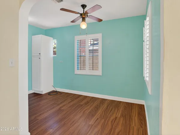 a view of a room with wooden floor and a ceiling fan