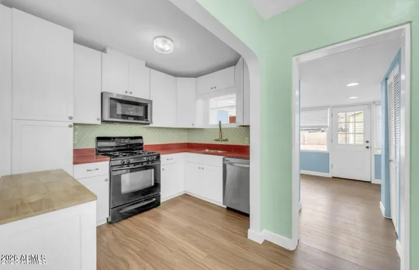 a kitchen with stainless steel appliances granite countertop a stove a sink and a microwave