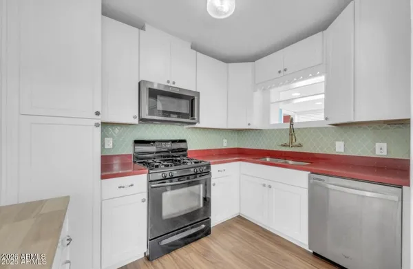 a kitchen with a refrigerator stove and wooden cabinets