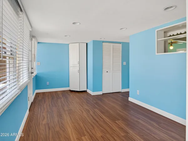 a view of a kitchen with a stove wooden cabinet a ceiling fan and windows