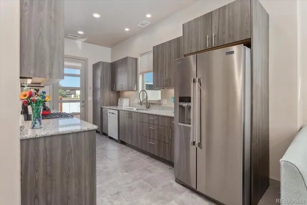 a kitchen with stainless steel appliances a refrigerator and a refrigerator