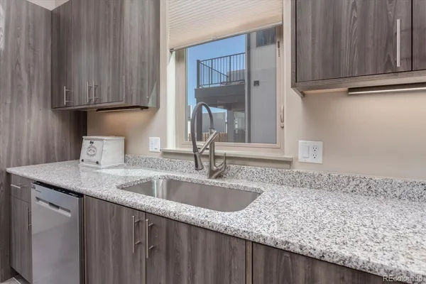 a kitchen with granite countertop a sink and cabinets