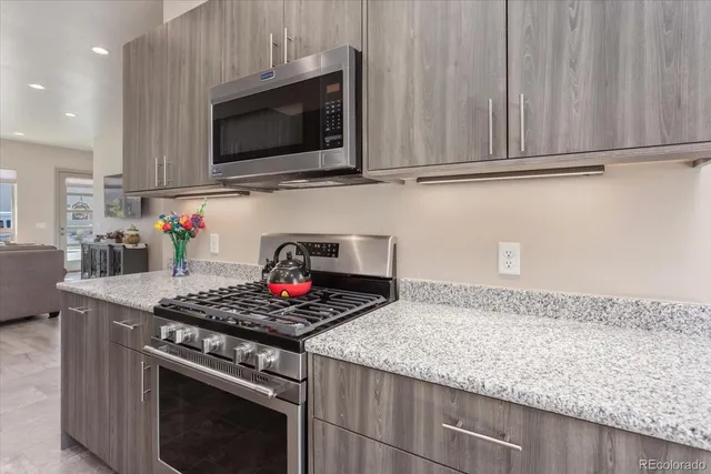 a kitchen with stainless steel appliances granite countertop a stove a microwave and cabinets