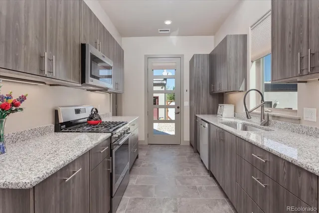 a kitchen with stainless steel appliances granite countertop a sink stove and cabinets