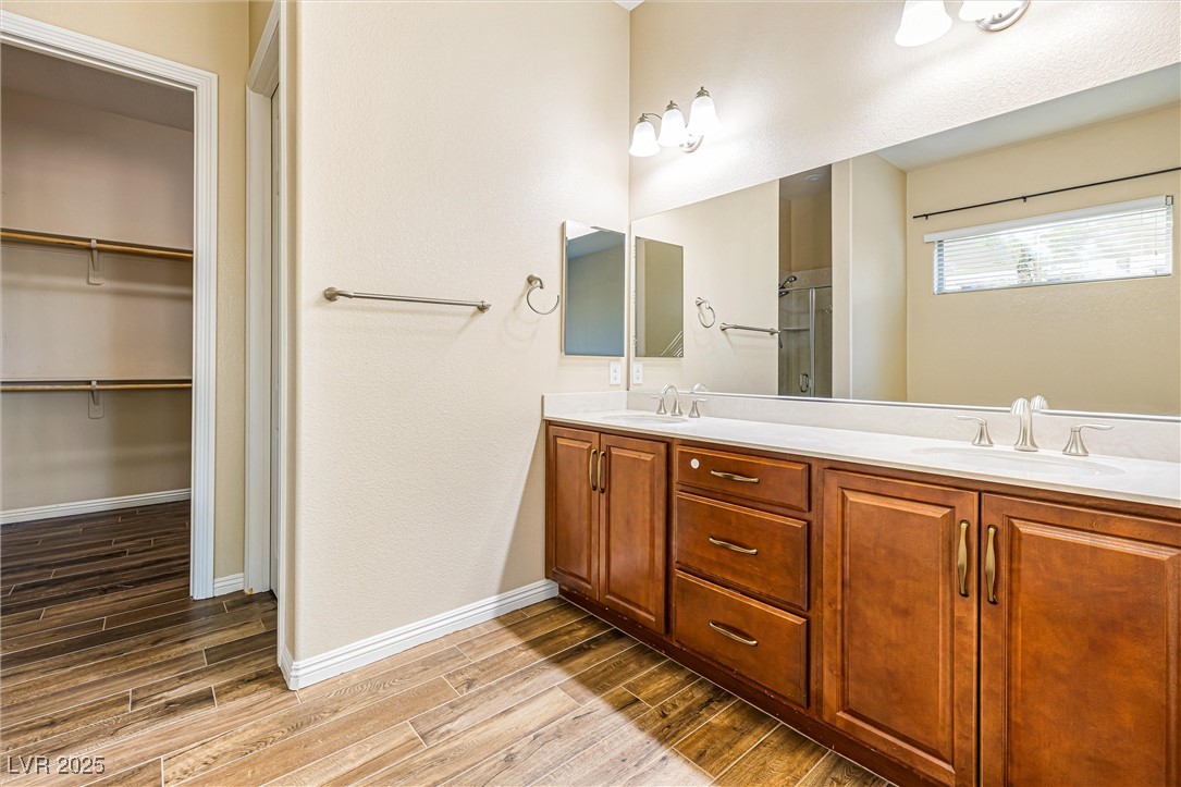 60 Newton Ridge Way Las Vegas, NV 89183 - Photo 18 of 44 Full bath featuring double vanity, wood tiled floors, a spacious closet, and a textured wall
