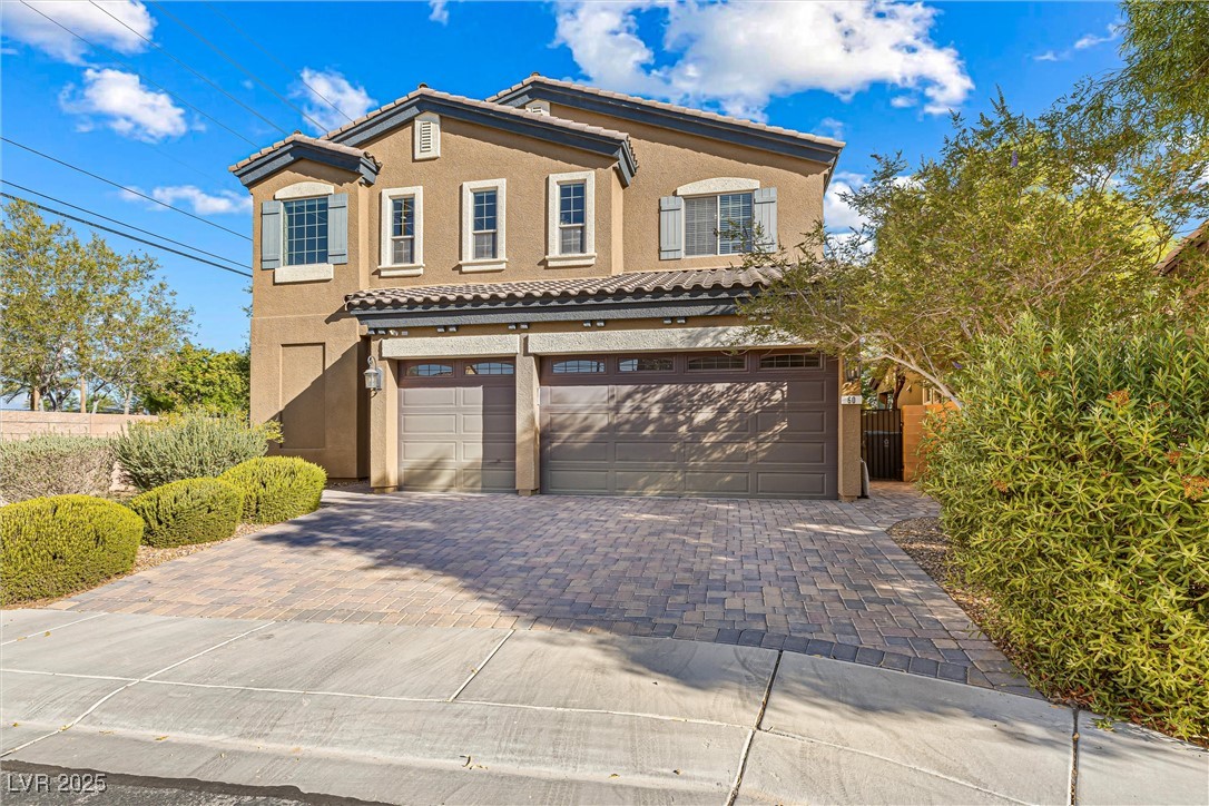 60 Newton Ridge Way Las Vegas, NV 89183 - Photo 2 of 44 View of front of property featuring stucco siding, decorative driveway, a tiled roof, and a garage