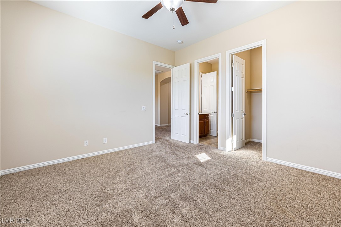 60 Newton Ridge Way Las Vegas, NV 89183 - Photo 24 of 44 Unfurnished bedroom with light carpet, a spacious closet, and ceiling fan