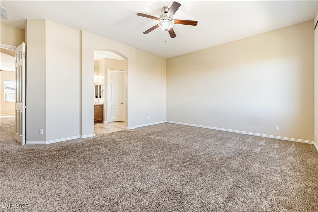 60 Newton Ridge Way Las Vegas, NV 89183 - Photo 28 of 44 Spare room featuring light colored carpet, ceiling fan, and arched walkways